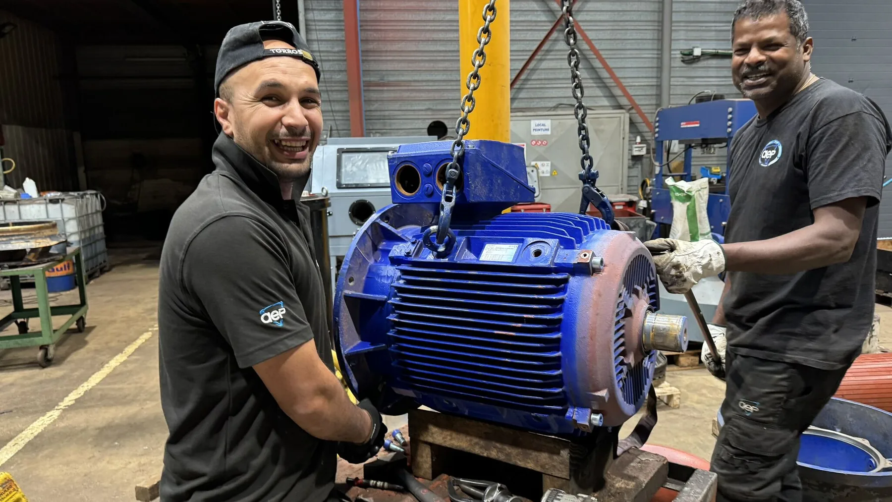 Deux techniciens AEP autour d’un moteur, en atelier