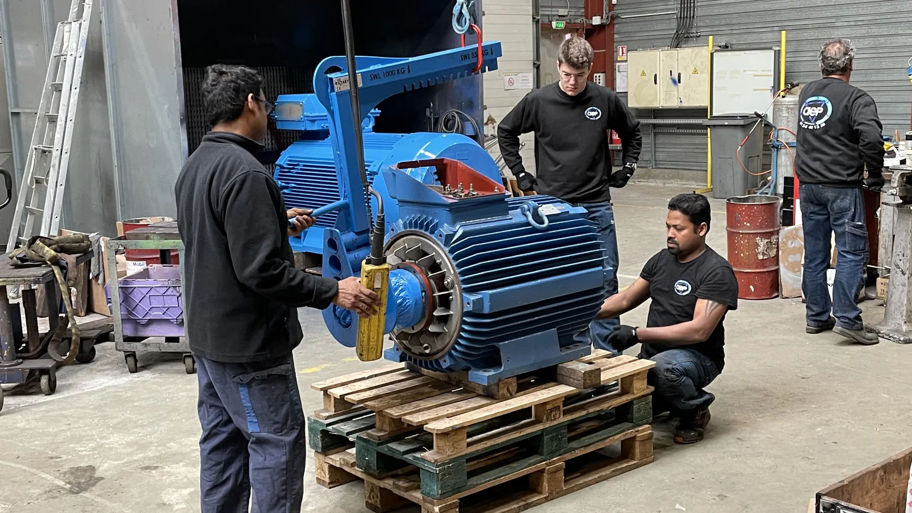 Équipe autour d’un moteur de forte puissance, en atelier