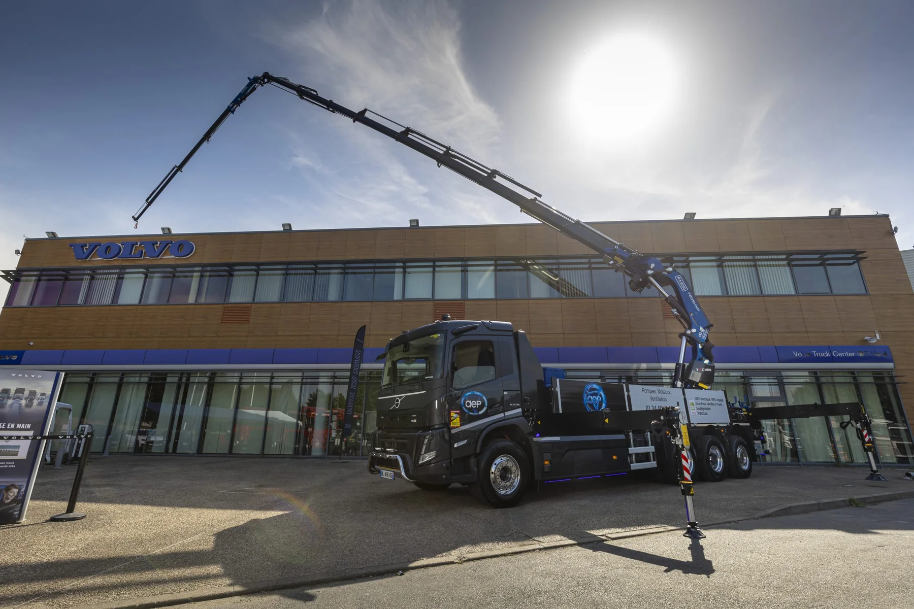 Camion-grue AEP bras déployé devant un concessionnaire