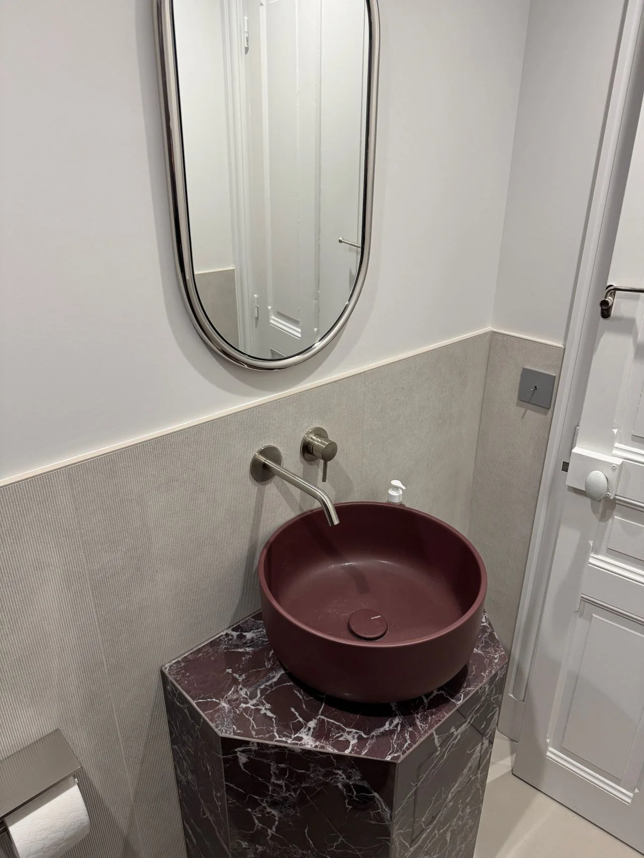 Aménagement haut de gamme d'un WC avec habillage effet marbre rouge à Deauville