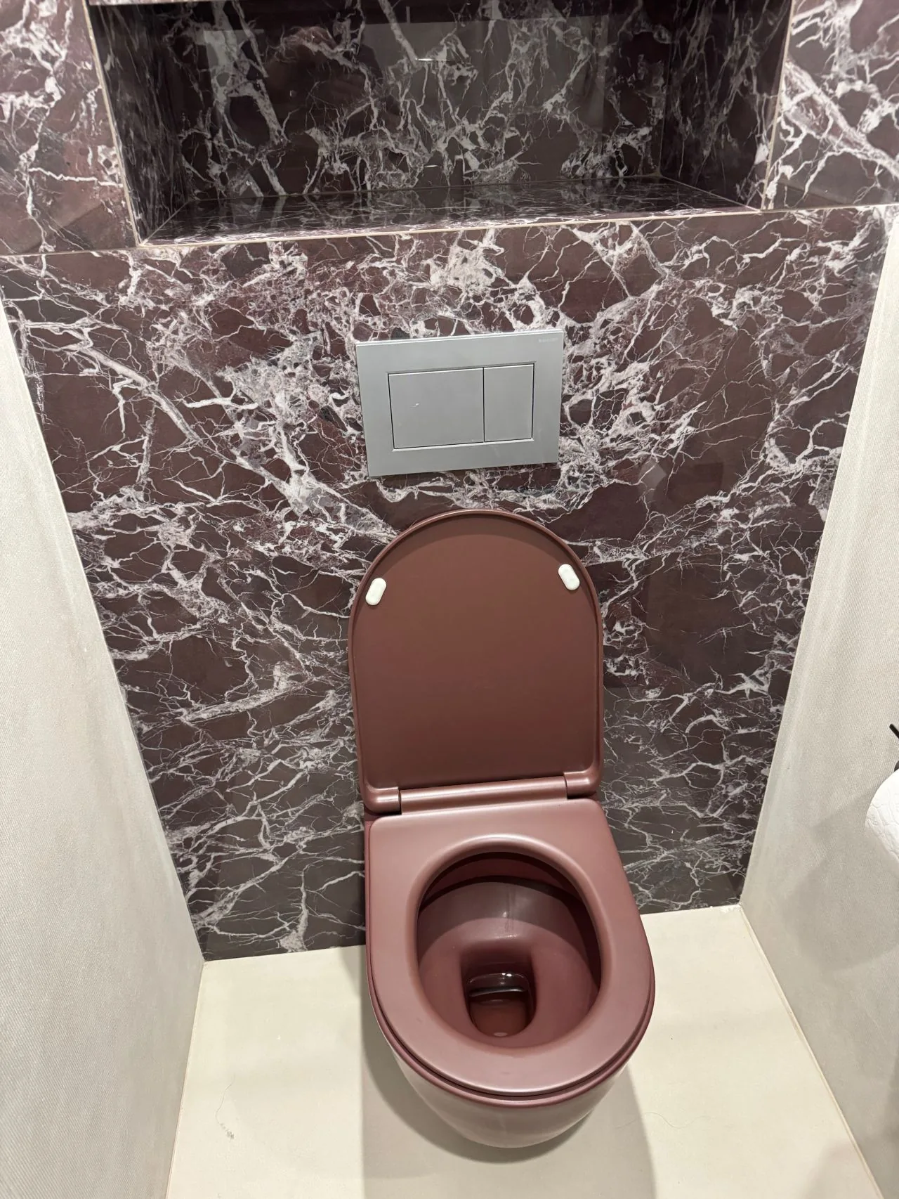Aménagement haut de gamme d'un WC avec habillage effet marbre rouge à Deauville