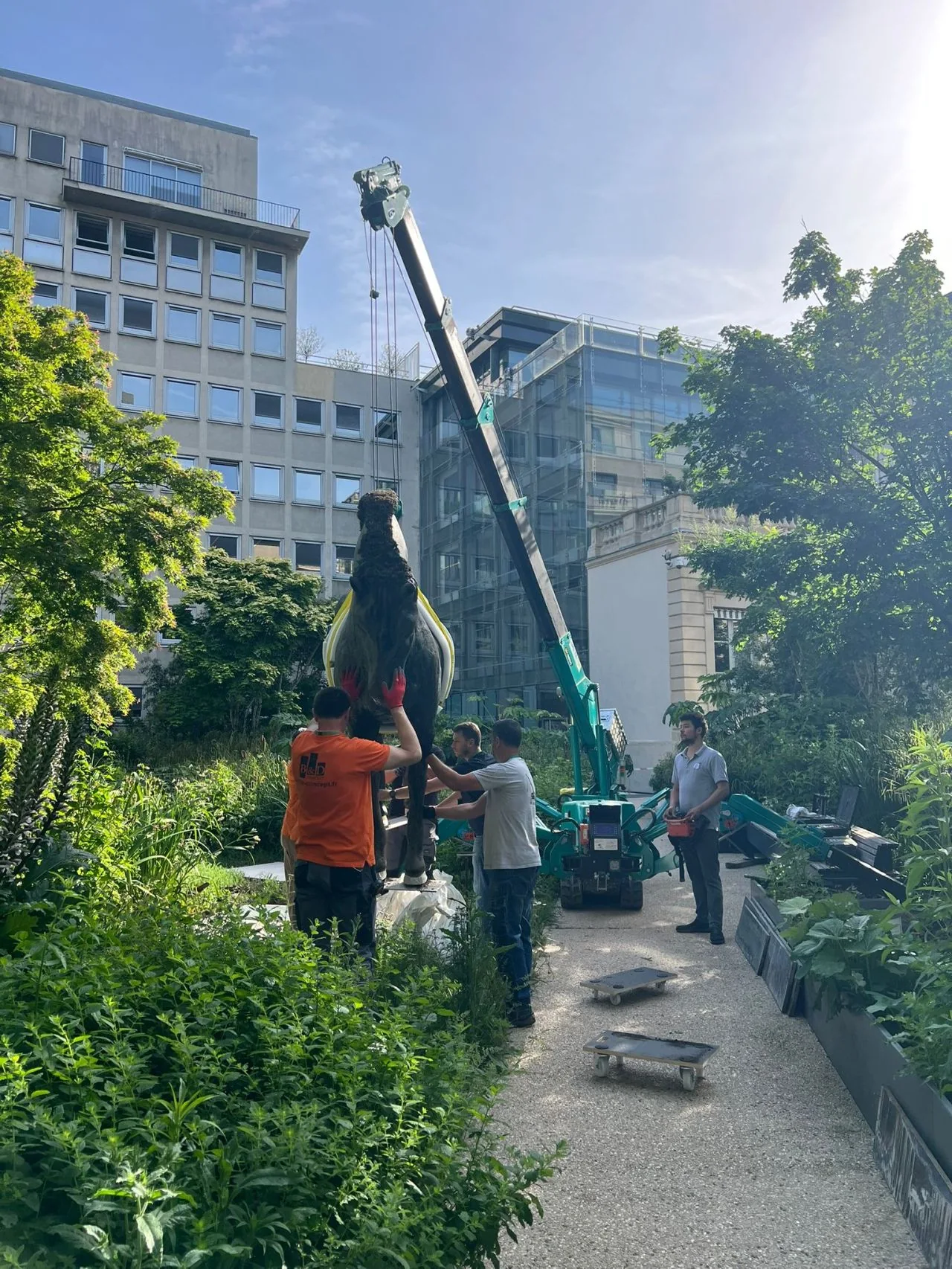 Installation de sculptures équines monumentales dans un jardin parisien